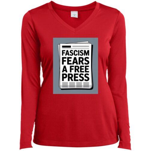 A red women's long-sleeve v-neck tee shirt features a newspaper graphic with the text "Fascism Fears A Free Press". Activist apparel promoting freedom of the press.