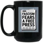 Black 15oz ceramic coffee mug with "Fascism Fears A Free Press" newspaper graphic. A political statement mug for activists and journalism supporters.