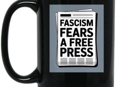 Black 15oz ceramic coffee mug with "Fascism Fears A Free Press" newspaper graphic. A political statement mug for activists and journalism supporters.